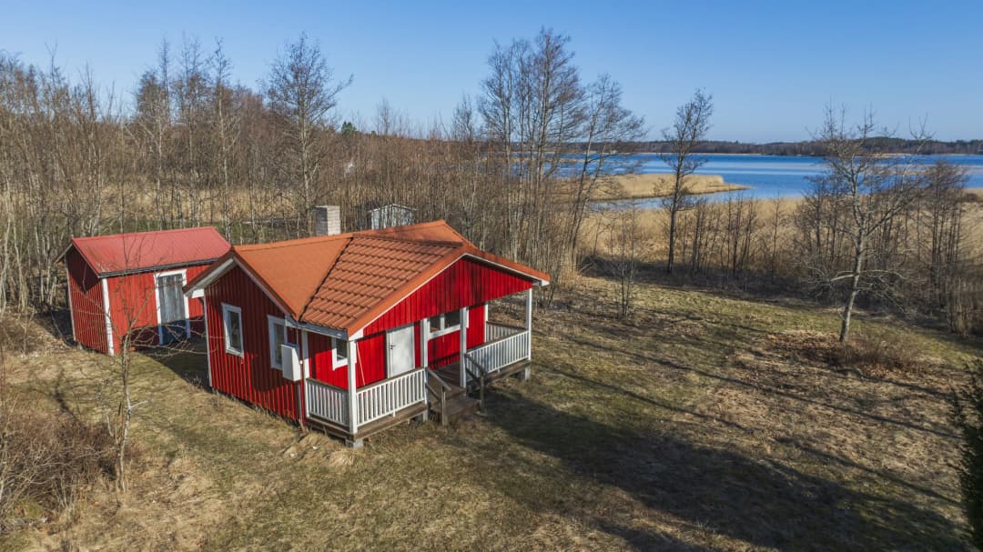 Bild av Charmig röd stuga i rofyllt kustlandskap